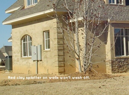 Yellow-orange mud splattered on painted stucco. House was several years old when photo was taken.